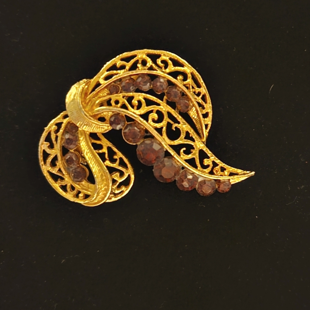 Gold trim with purple gem ribbon brooch